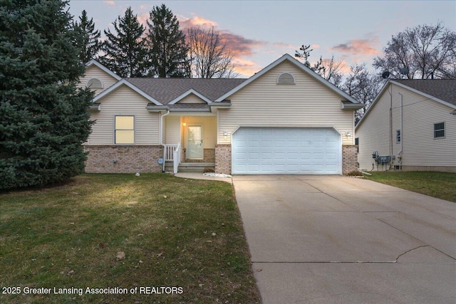 ranch-style house with an attached garage, concrete driveway, a lawn, and brick siding