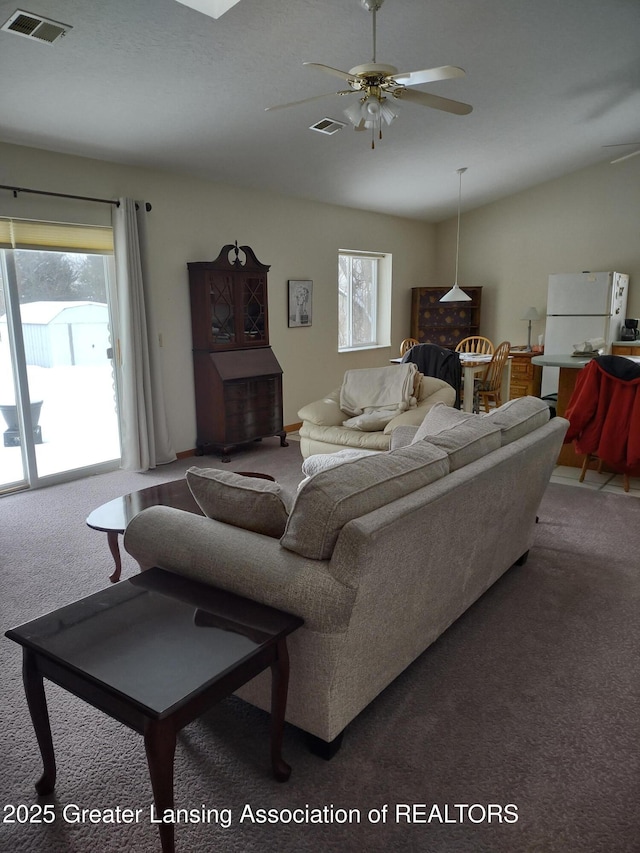 living room featuring carpet floors, visible vents, and vaulted ceiling