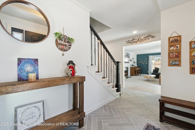 entryway featuring ornamental molding and parquet flooring