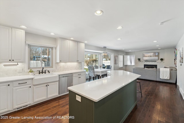 kitchen featuring stainless steel dishwasher, sink, a breakfast bar, and white cabinets