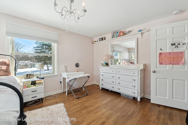 bedroom featuring multiple windows, hardwood / wood-style flooring, and an inviting chandelier