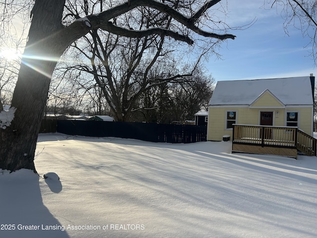 yard layered in snow with a deck