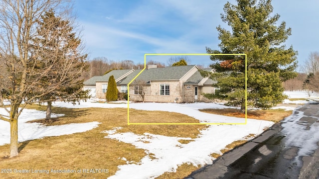 view of front of house with stone siding and a chimney