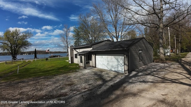 garage with aphalt driveway and a water view