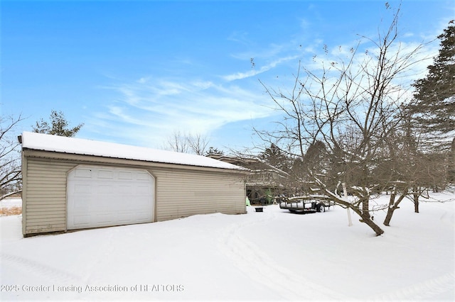 snow covered garage with a detached garage