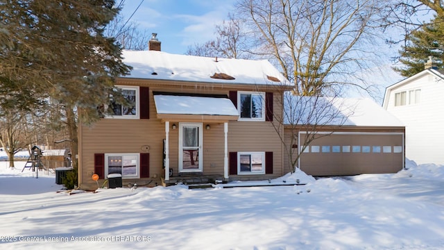 bi-level home with a garage, a chimney, and central AC unit