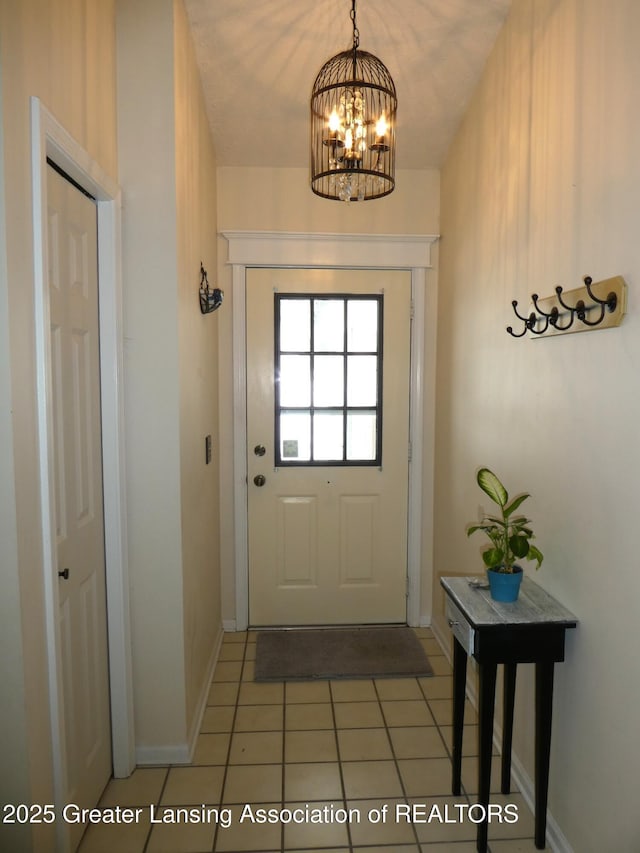 entryway featuring a chandelier, light tile patterned flooring, and baseboards