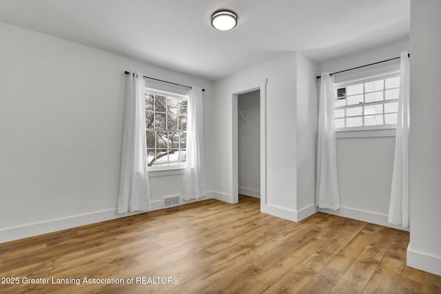 unfurnished bedroom featuring light wood-type flooring, visible vents, and baseboards