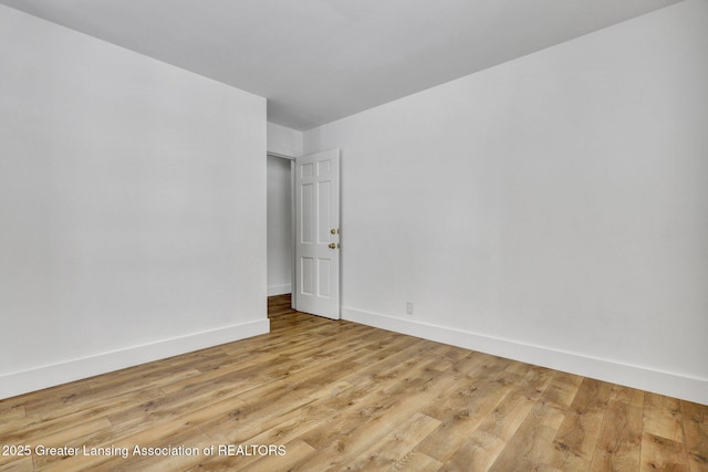 empty room featuring light wood finished floors and baseboards