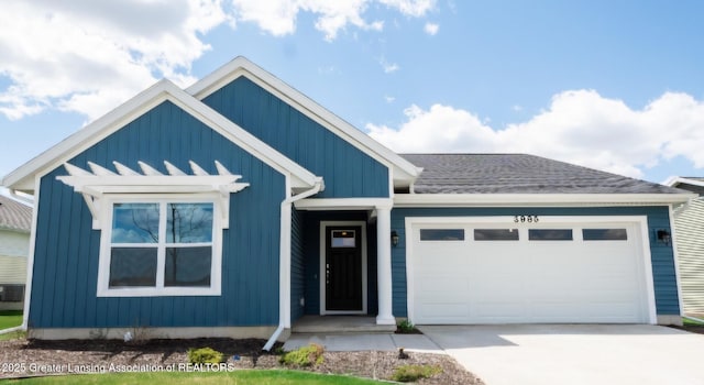 view of front facade with an attached garage, a shingled roof, board and batten siding, and concrete driveway