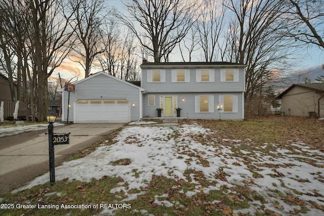 colonial inspired home featuring driveway, an attached garage, and a chimney