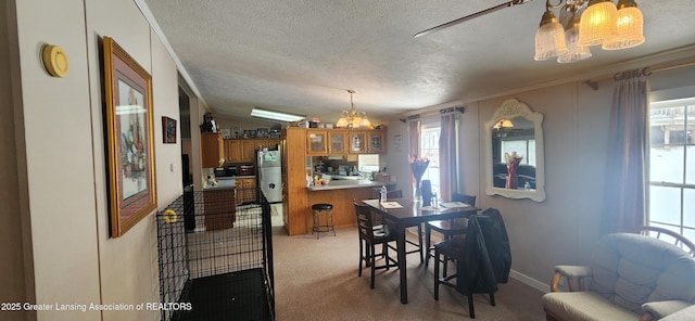 dining room with light carpet, ornamental molding, and a textured ceiling