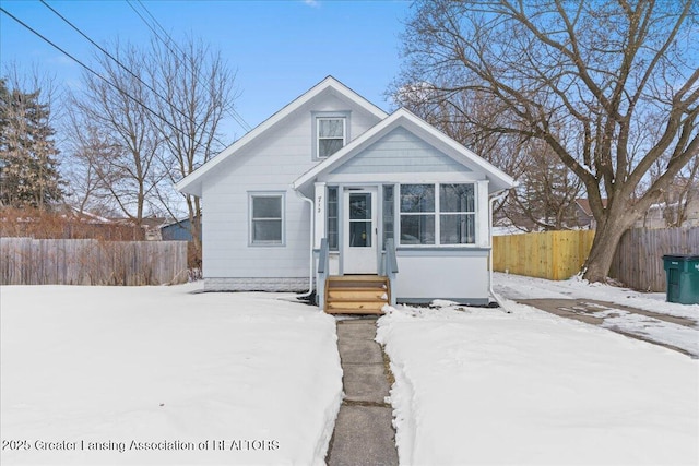 bungalow-style house with entry steps and fence private yard