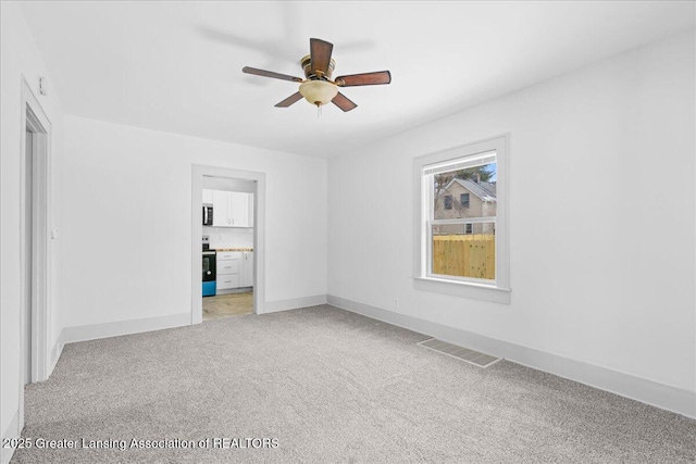 unfurnished bedroom with baseboards, visible vents, ceiling fan, ensuite bathroom, and carpet flooring