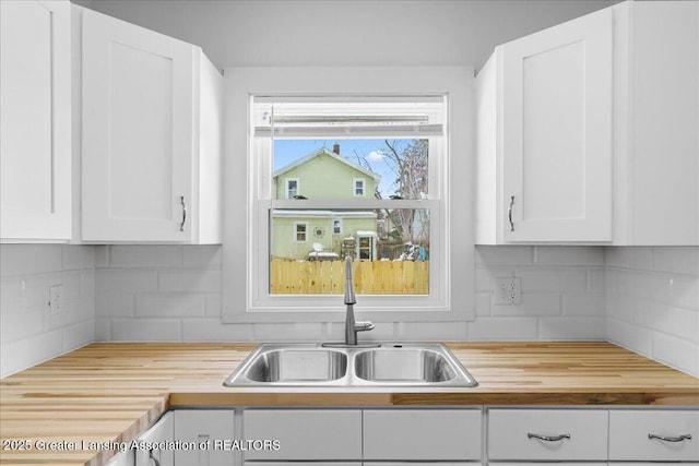 kitchen featuring white cabinetry and a sink