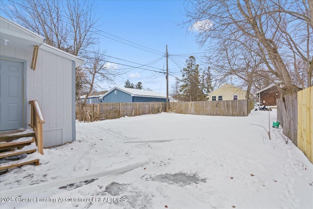 yard covered in snow with entry steps and fence