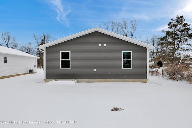 view of snow covered rear of property