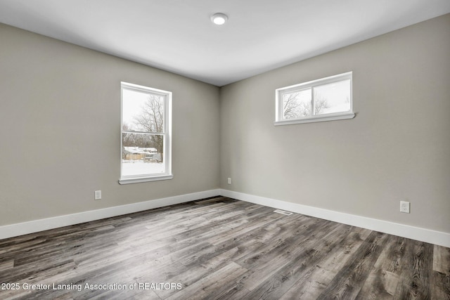 spare room featuring wood finished floors and baseboards