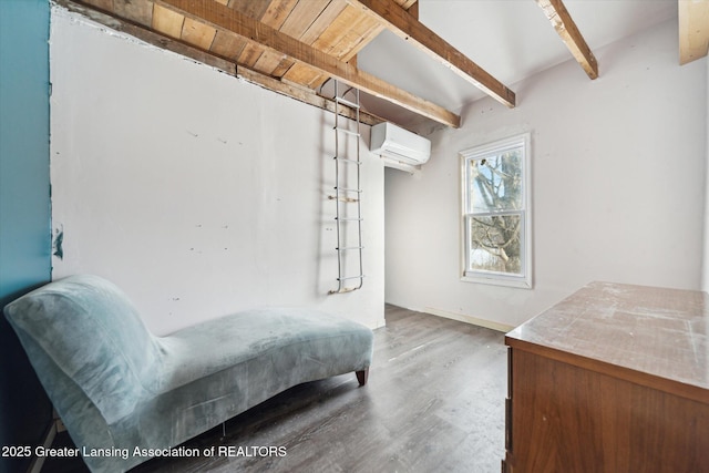 bedroom featuring wood finished floors, beamed ceiling, and a wall mounted air conditioner