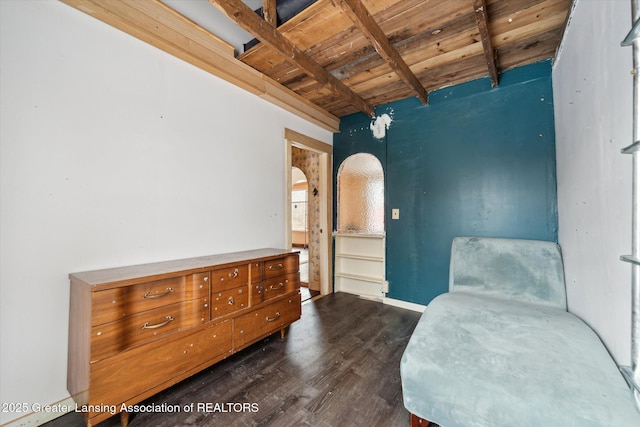 bedroom with wood ceiling, arched walkways, dark wood finished floors, and beam ceiling