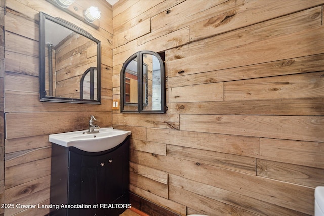 bathroom featuring wood walls and vanity