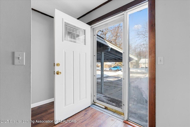 doorway featuring wood finished floors and baseboards