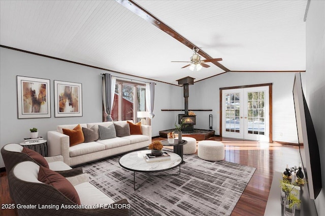 living area featuring french doors, crown molding, vaulted ceiling with beams, a wood stove, and wood finished floors