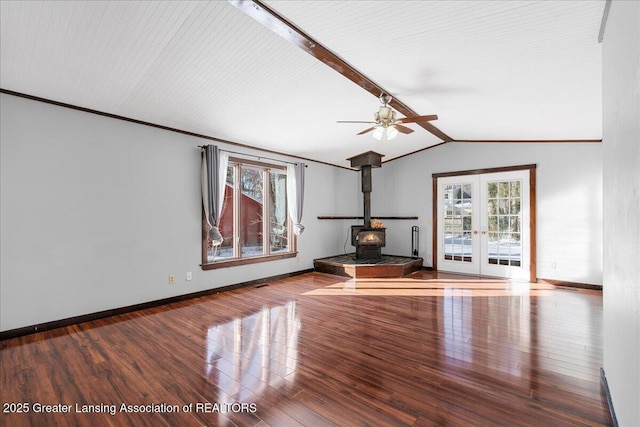 unfurnished living room with a wood stove, vaulted ceiling with beams, a healthy amount of sunlight, and french doors