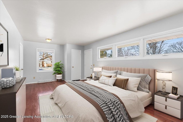 bedroom with dark wood-style floors, visible vents, and baseboards