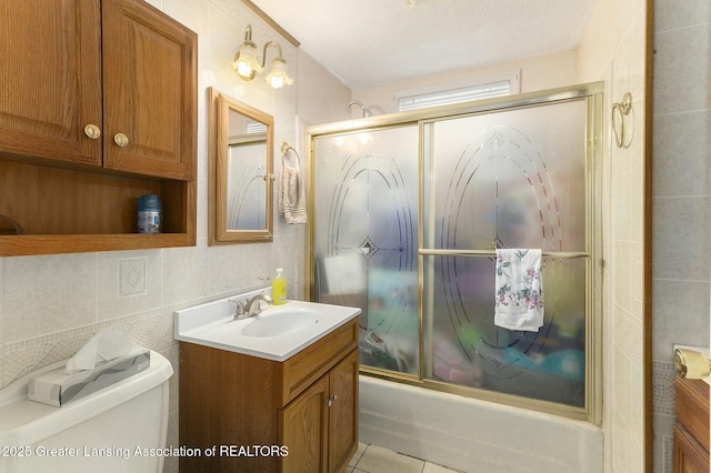 bathroom featuring toilet, shower / bath combination with glass door, tile patterned floors, and vanity