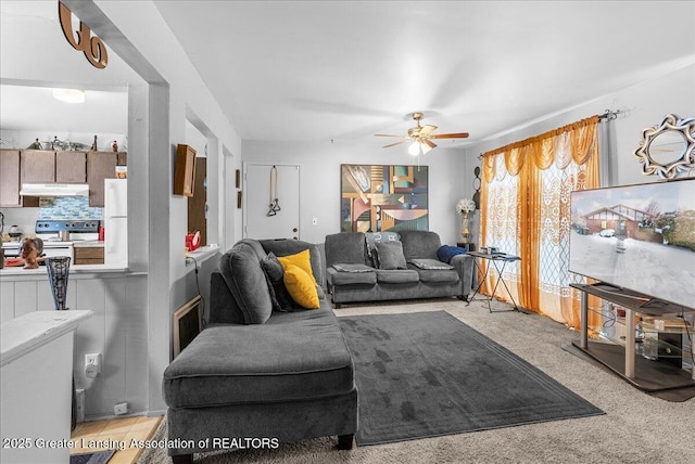 living area featuring light carpet and ceiling fan