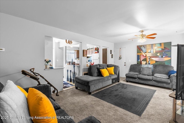 living room featuring carpet flooring and a ceiling fan