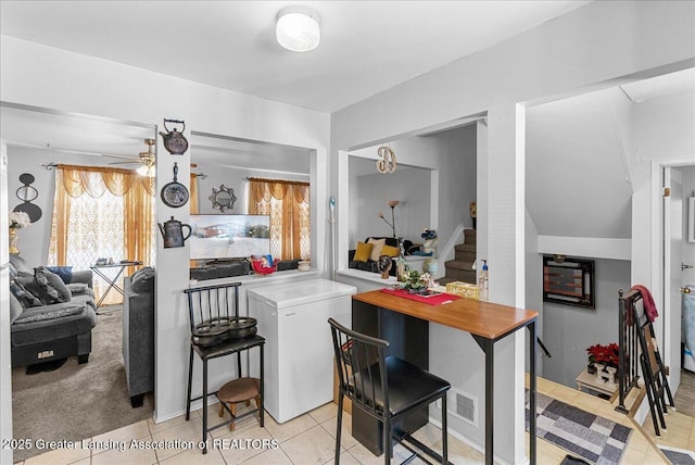 kitchen featuring refrigerator, visible vents, light countertops, ceiling fan, and a peninsula