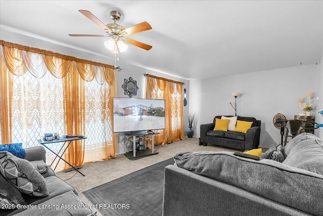 carpeted living area with ceiling fan