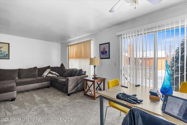 carpeted living area with ceiling fan