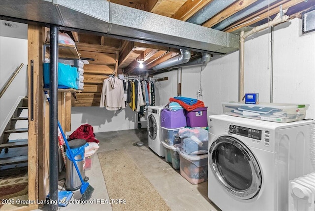 unfinished below grade area featuring stairway and independent washer and dryer