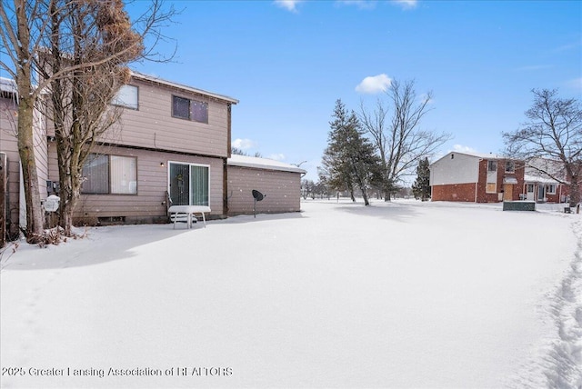 view of snow covered back of property