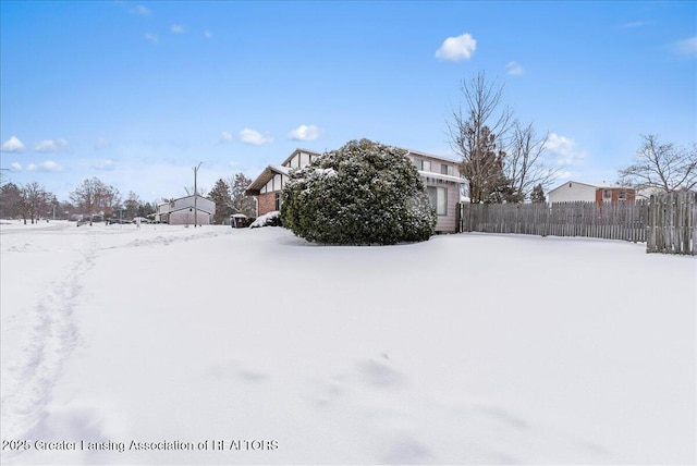 snowy yard featuring fence