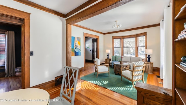 living room featuring ornamental molding, wood finished floors, and baseboards