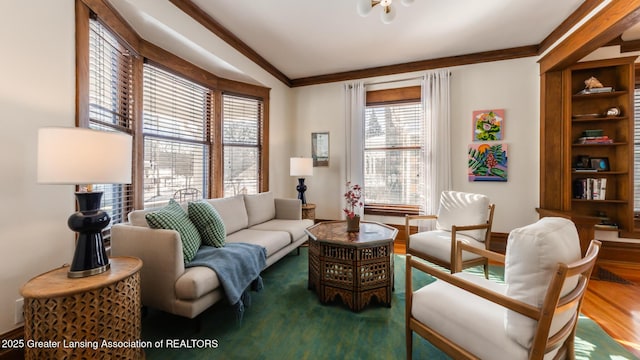 living area with crown molding and wood finished floors