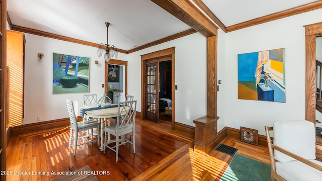 dining space with baseboards, wood finished floors, and crown molding