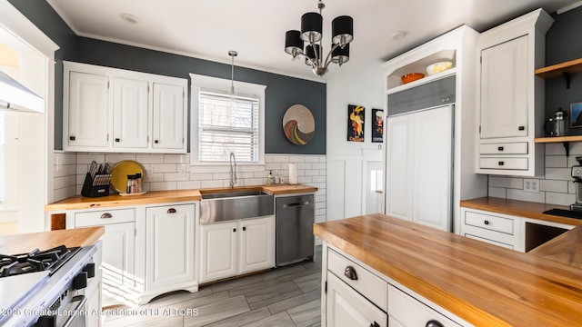 kitchen featuring pendant lighting, white cabinetry, wood counters, and dishwashing machine