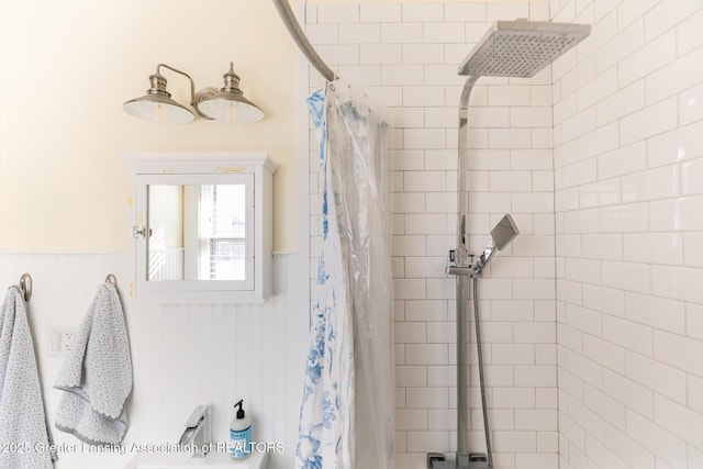 bathroom featuring a tile shower and wainscoting