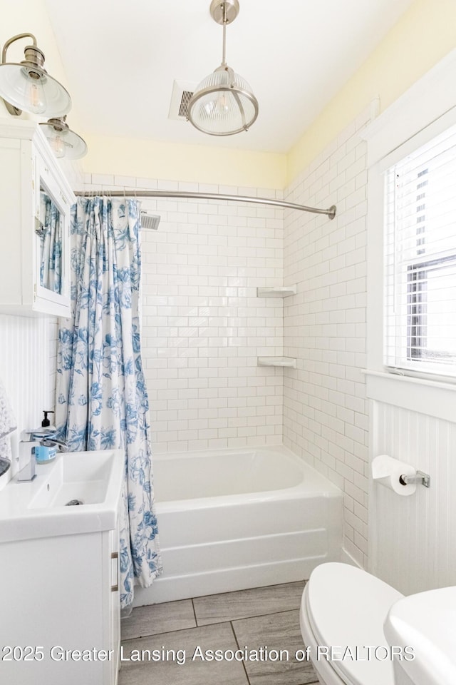 bathroom with shower / bath combo, visible vents, a sink, and toilet