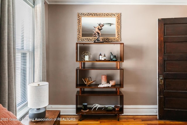 interior details with baseboards, crown molding, and wood finished floors