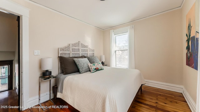 bedroom with baseboards and dark wood-style flooring