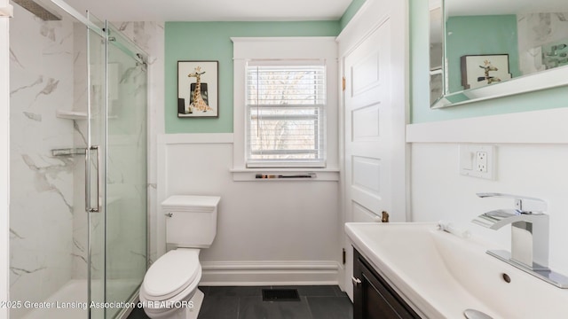 full bath with a marble finish shower, visible vents, toilet, vanity, and baseboards