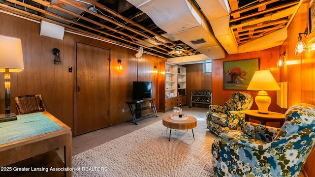 living area with visible vents and wooden walls