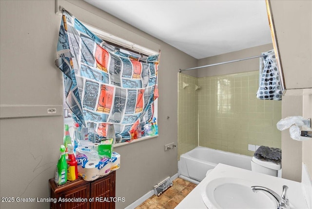 bathroom featuring toilet, shower / bath combination, visible vents, vanity, and baseboards