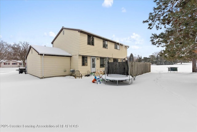 snow covered property with a trampoline